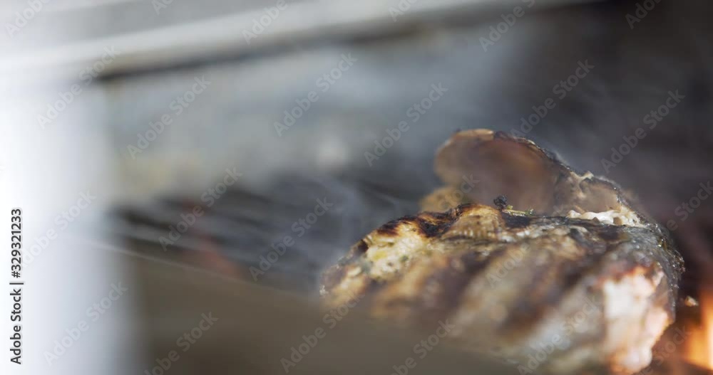 Cook Grilling fish in kitchen Cook Grilling fish in kitchen