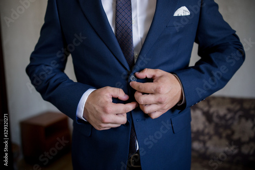 man in suit fastens button