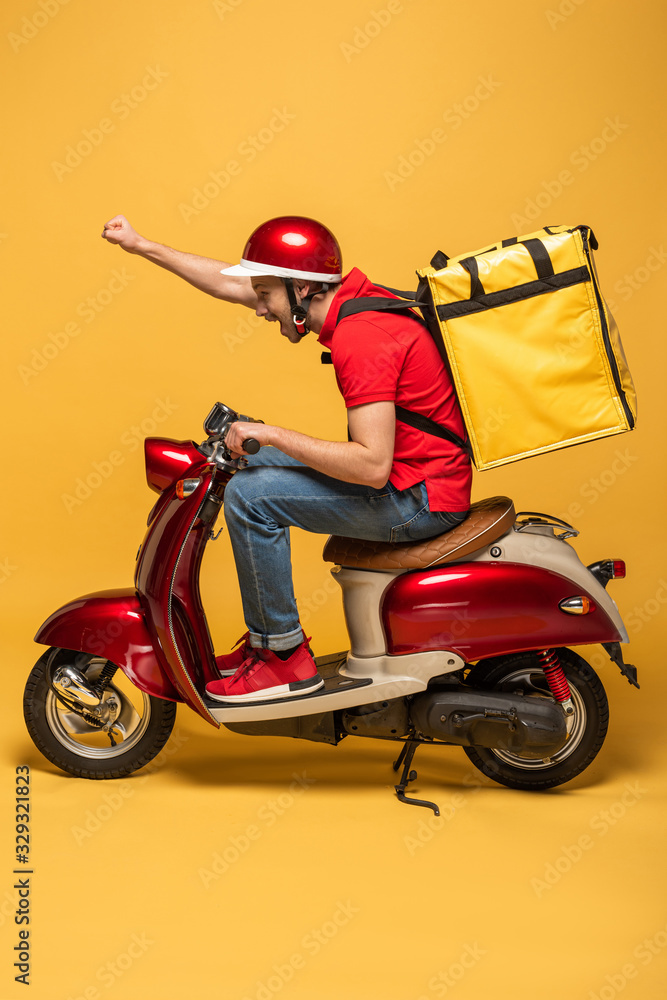 side view of delivery man with backpack on scooter on yellow background ...