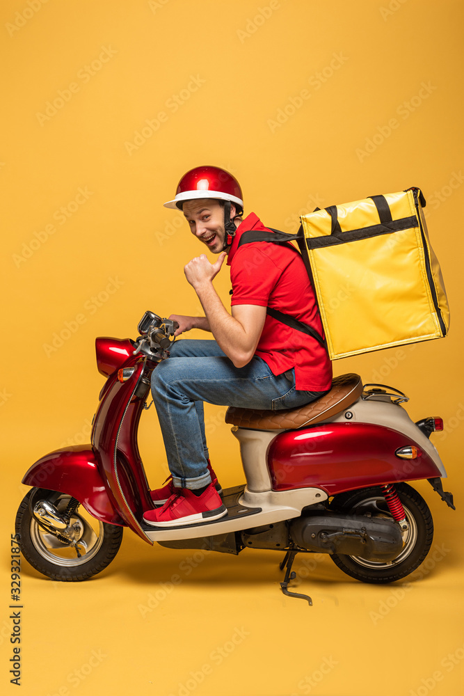 Side View Of Happy Delivery Man With Backpack On Scooter On Yellow 