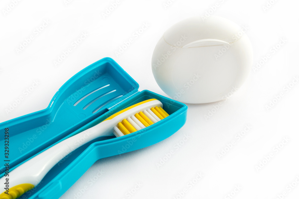 Toothbrush in a plastic case and dental floss on white background Toothbrush in a plastic case and dental floss on white background
