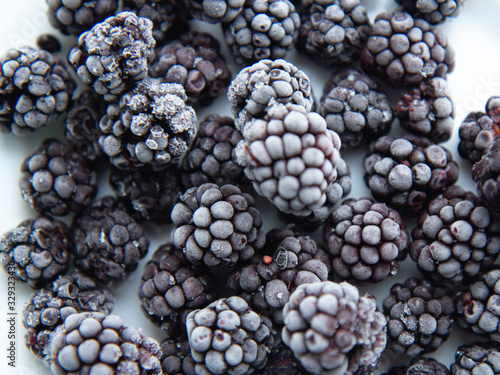 Frozen blackberries on a white plate. Front view