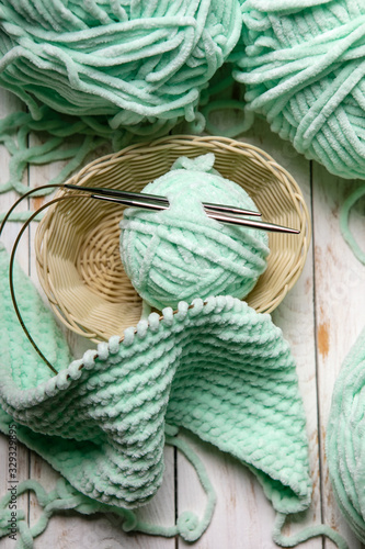 Balls of yarn in basket with knitting needles