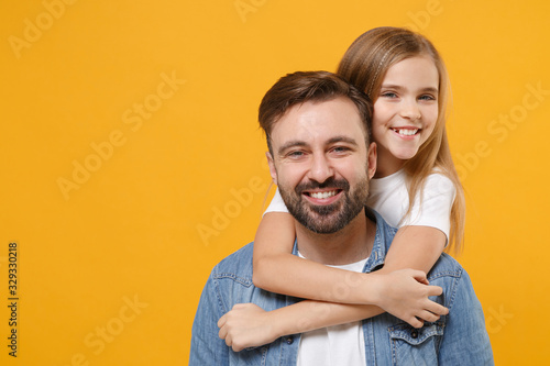 Smiling bearded man in casual clothes have fun with cute child baby girl. Father little kid daughter isolated on yellow background in studio. Love family day parenthood childhood concept. Hugging.