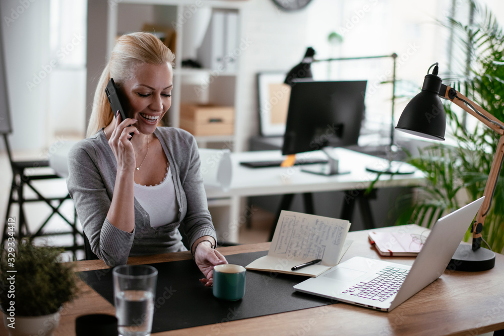 Businesswoman using phone. Happy young woman talking on smartphone in office. Businesswoman using phone. Happy young woman talking on smartphone in office.