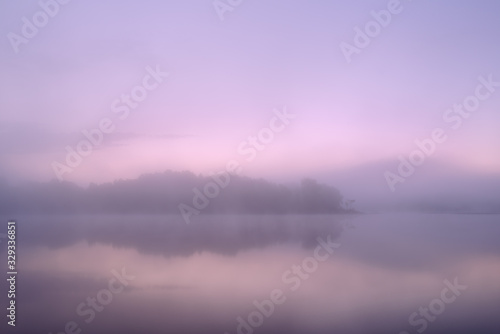 Fototapeta Naklejka Na Ścianę i Meble -  Spring landscape at dawn of the shoreline of Whitford Lake with reflections in calm water, Fort Custer State Park, Michigan, USA