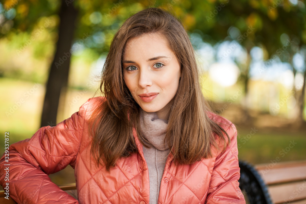 Close up portrait of a young beautiful brunette woman in coral coat Close up portrait of a young beautiful brunette woman in coral coat