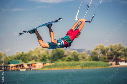 Professional kiter makes the difficult trick on a river. Kitesurfing Kiteboarding action photos man among waves quickly goes