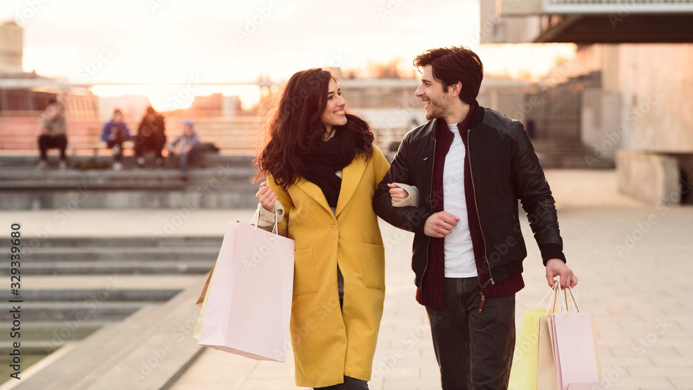 Couple walking carrying their shopping paper bags
