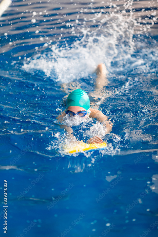Cute little girl swimmer training in a swimming pool
