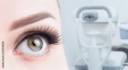 Female eye close-up on the background of ophthalmic equipment. Microscopy, vision diagnostics, treatment concept
