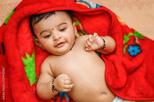 Cute indian little boy playing on bed 