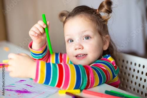 little girl drawing with color pencils