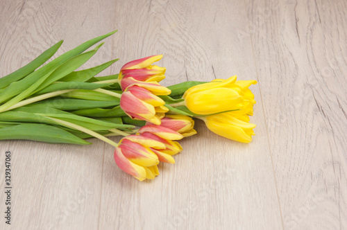 Yellow tulips over wooden table background with copy space