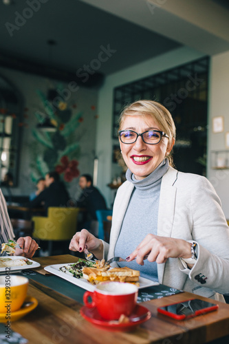 mid aged woman eating breakfast or lunch in food corner