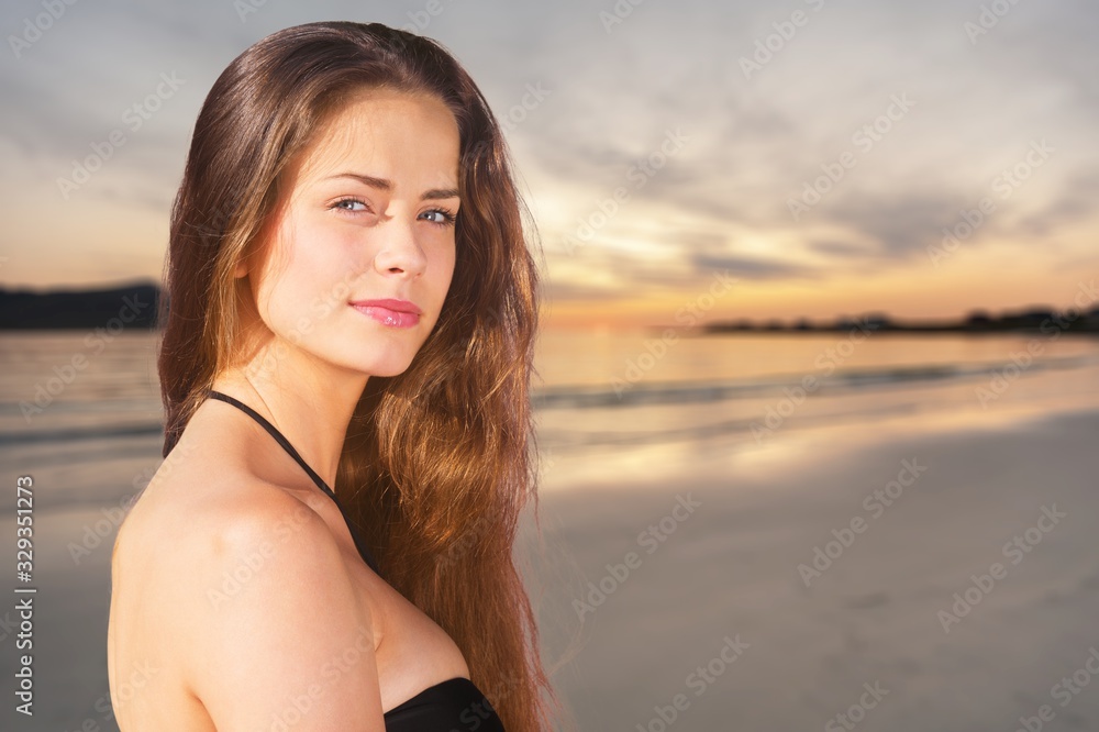 Beautiful young woman on beach background