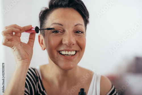 mid aged woman brushing her eyelashes