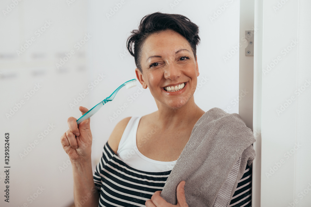 woman holding toothbrush and towel at her home woman holding toothbrush and towel at her home