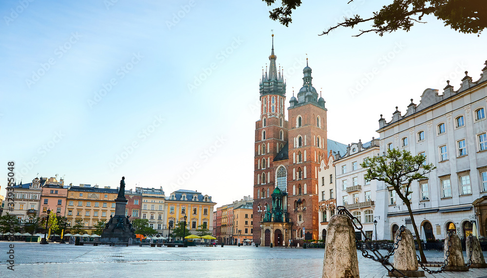 Krakow's Main Square (Rynek Glowny) with St. Mary's Basilica church and Adam Mickiewicz Monument located at center of the Old Town district in Lesser, Poland