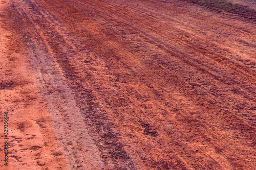 Red dirt road polluted with the iron ore. Environmental pollution