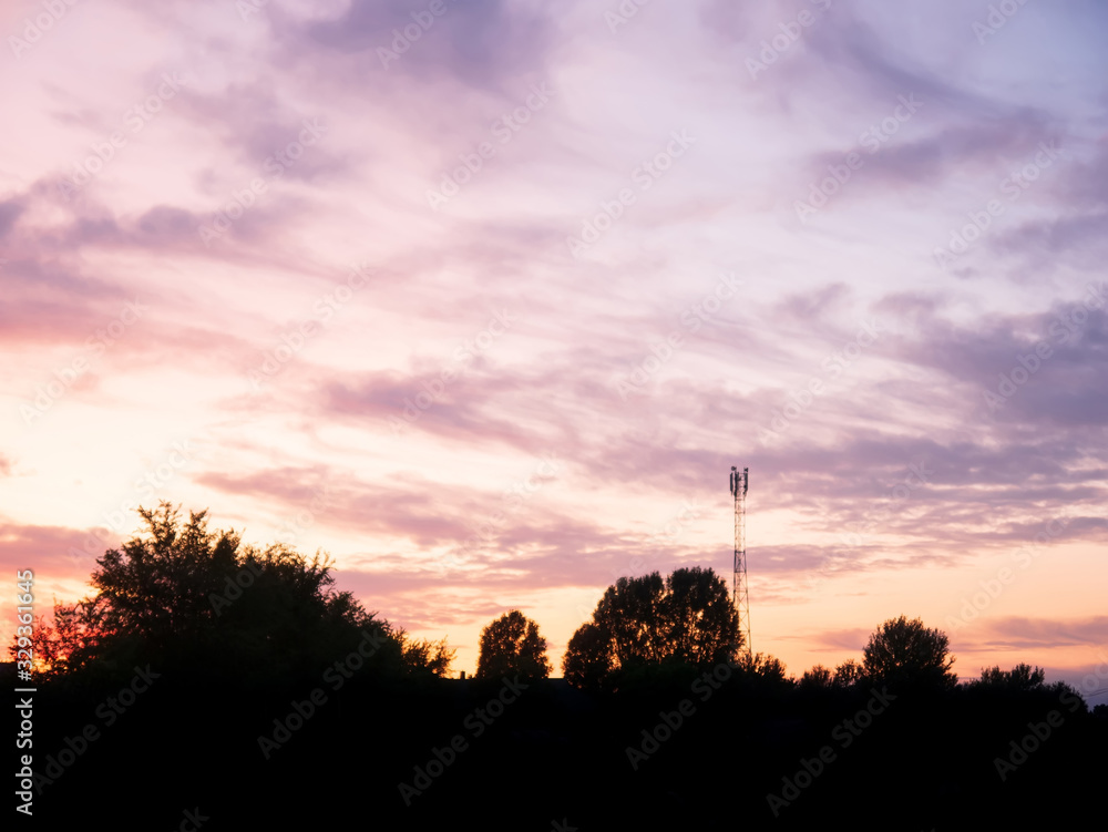 view over a beautiful sunset behind a radio antenna tower.