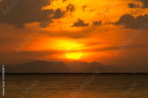Sunset sky at the lake with clouds and silhouette mountain.