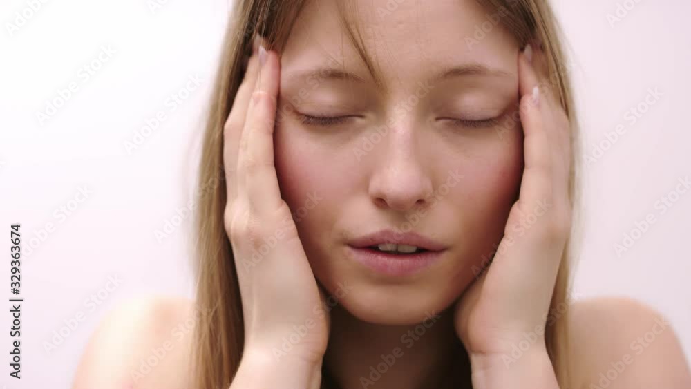Tired woman feeling sick suffering from strong headache or migraine over white background. Concept of emotions Tired woman feeling sick suffering from strong headache or migraine over white background. Concept of emotions