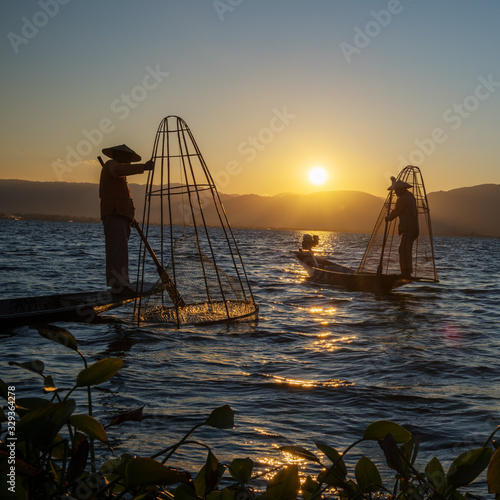 Myanmar, Shan state, Inle lake Intha fisherman on boat at amazing sunset