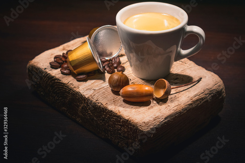 Cup of coffee in woodden background with coffee capusles ands coffee beans