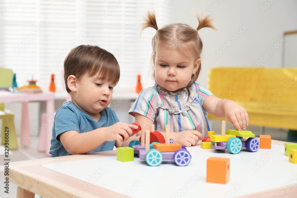 Little children playing with construction set at table Little children playing with construction set at table