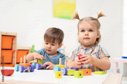 Little children playing with construction set at table
