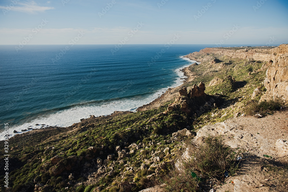 beautiful rugged coastline with waves crashing against the cliffs