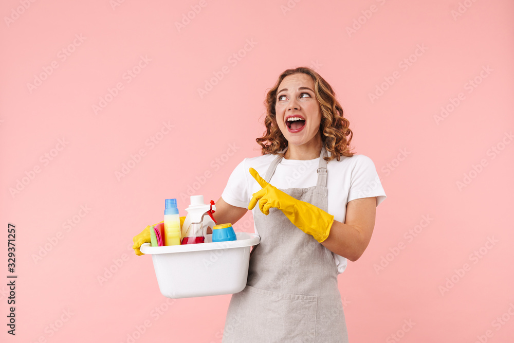 Housewife isolated holding cleansers pointing. Housewife isolated holding cleansers pointing.