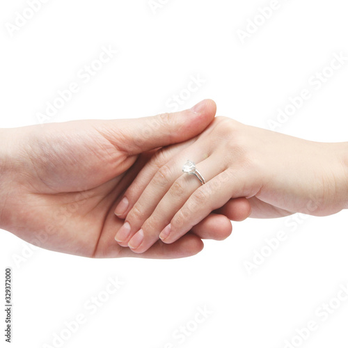 Ring with a stone on her hand. Male hand holds a female hand on a white background. Body parts.