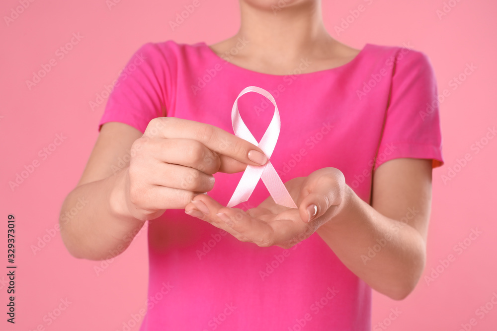 Woman holding pink ribbon on color background, closeup. Breast cancer awareness Woman holding pink ribbon on color background, closeup. Breast cancer awareness