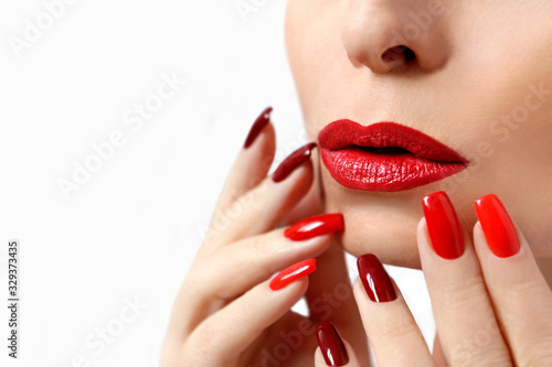 Fashionable makeup and manicure in dark red and light shades of nail Polish.Creative nail art on a young girl on a white background.