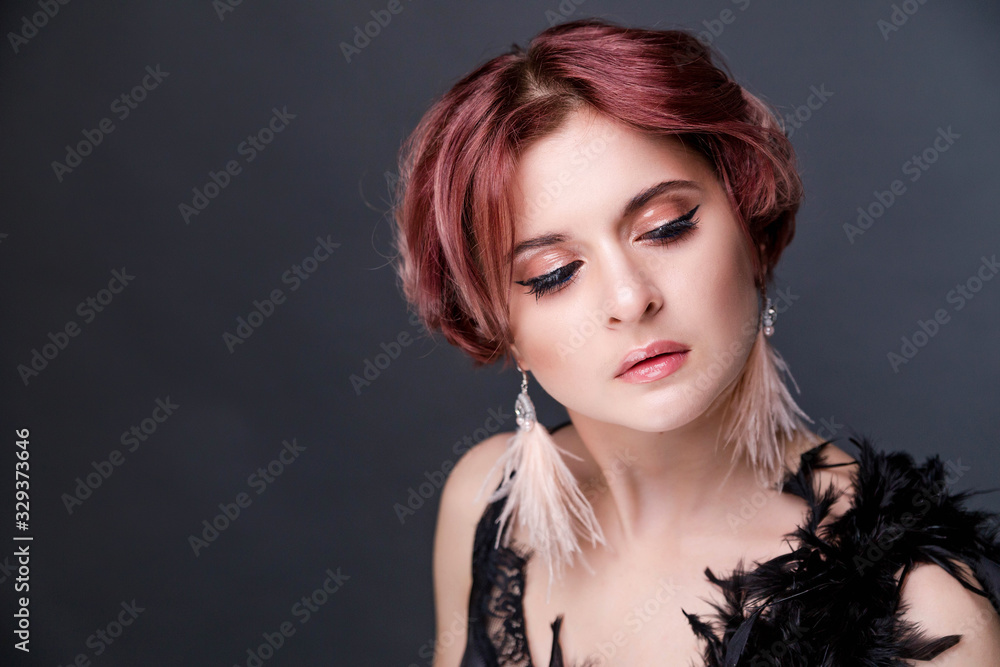 Beautiful retro woman from the roaring 20s is posing on black background Beautiful retro woman from the roaring 20s is posing on black background