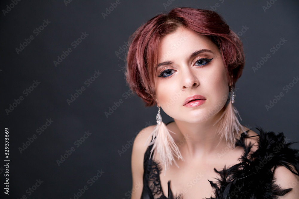 Beautiful retro woman from the roaring 20s is posing on black background Beautiful retro woman from the roaring 20s is posing on black background
