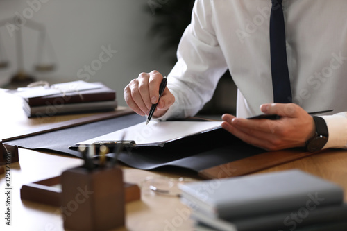 Male lawyer working at table in office, closeup