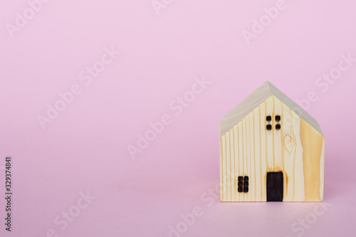 Wooden house model on pink ...