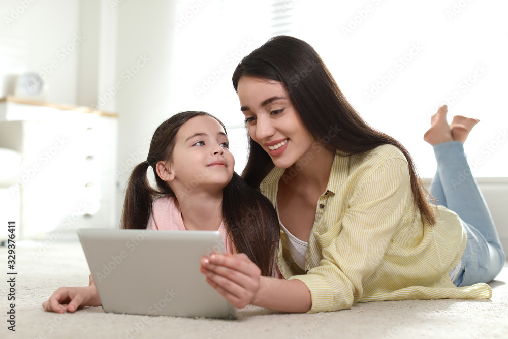 Mother and daughter reading E-book together at home Mother and daughter reading E-book together at home