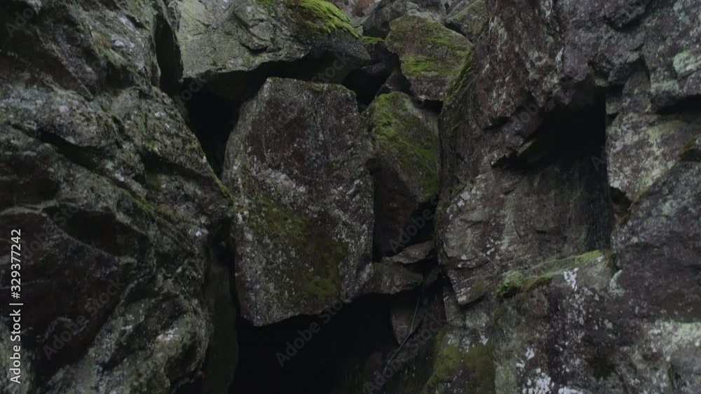 Drone shot flying up in ravine. Dark cave and mossy rocks, nature background in 4K resolution Drone shot flying up in ravine. Dark cave and mossy rocks, nature background in 4K resolution
