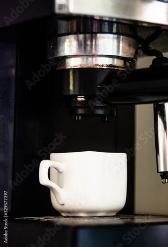 A coffee machine makes espresso in a small mug