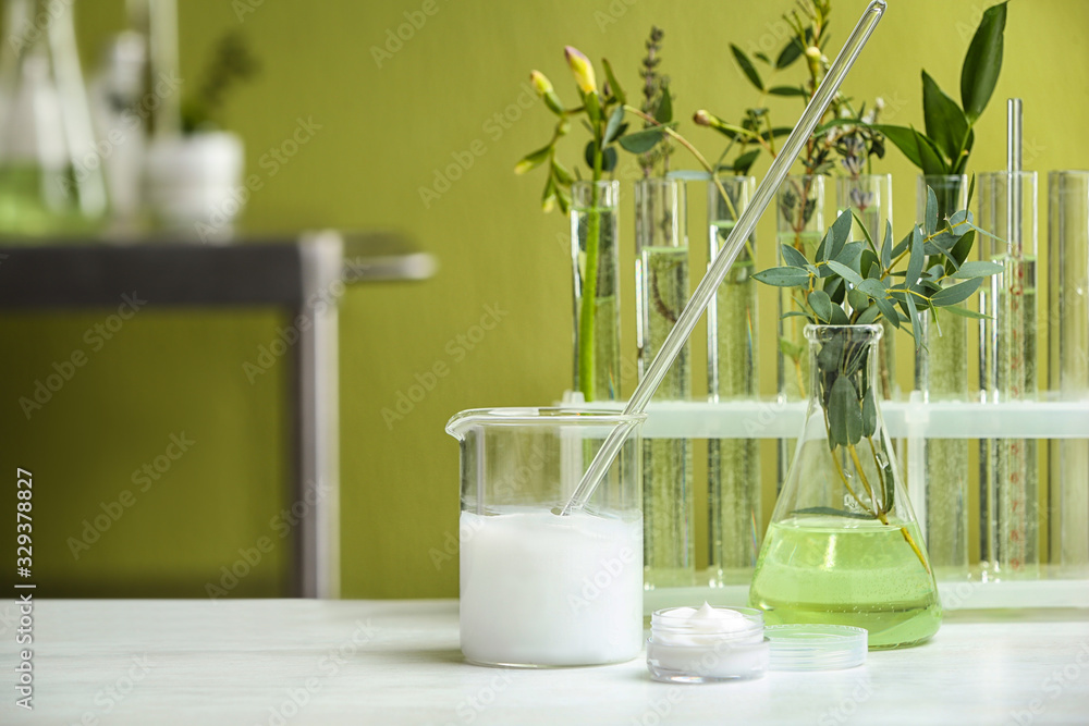 Cream and natural ingredients on white table in cosmetic laboratory Cream and natural ingredients on white table in cosmetic laboratory