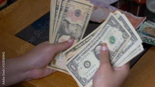 Young woman hand counting small dollars money