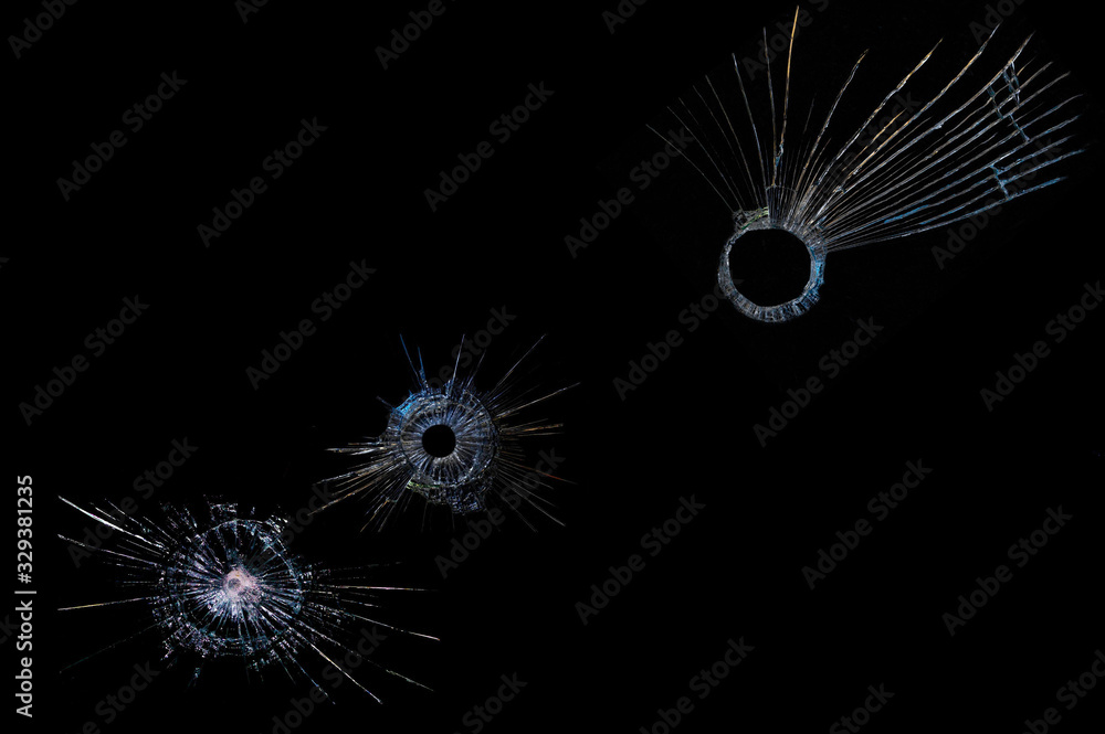Obraz premium cracks on a black background on broken glass from bullet shots