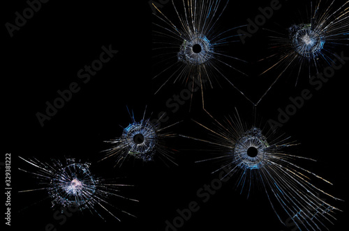 cracks on a black background on broken glass from bullet shots
