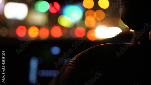 Colorful traffic light at night blur background view from car interior behind leather seat view
