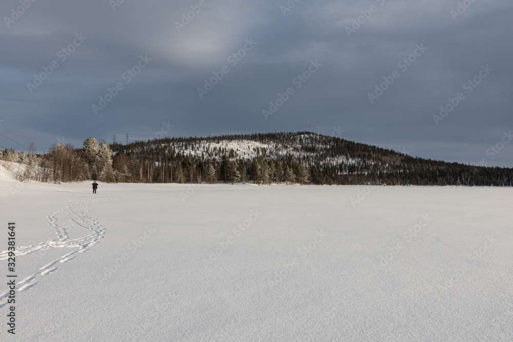 Winter landscape - snow-capped lake mountain and trees in the distance