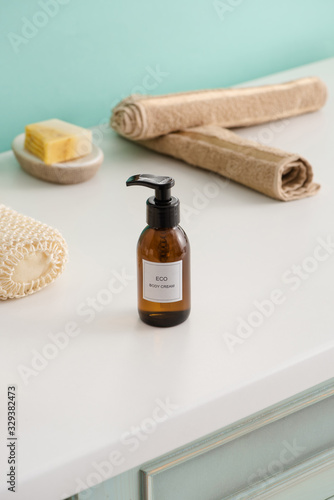 Selective focus of hygiene objects with bottle of eco body cream in bathroom, zero waste concept